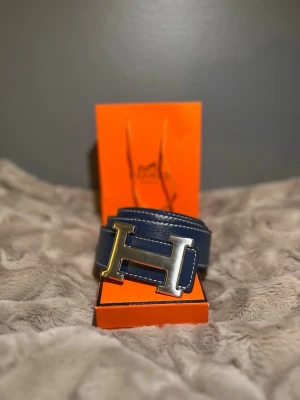 Läderbälte 110 cm  - Säljer ett exklusivt läder bälte då det var för stort i storleken. Klassisk och tidlös modell som passar både vardag och fest. Bältet har en marinblå läderyta men kan vändas för att användas som svart. Aldrig använt och därmed i nytt skick. Priset är ej hugget i sten.