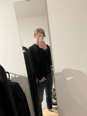 Svart 100% merinoullströja från Morris - Säljer en stilren svart tröja från Morris i 100% merinoull. Tröjan har rund halsringning, diskret broderad logga på bröstet och långa ärmar. Perfekt för dig som gillar klassisk och enkel stil. Storlek M men är liten i storleken. Jag på bilden är 175 och väger 65 kg. 