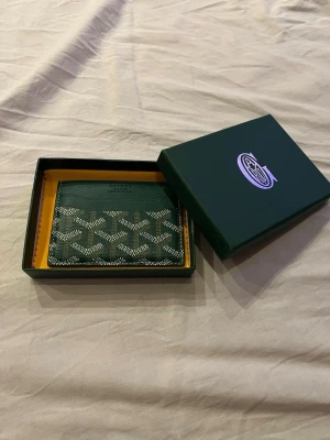 GoY4ard korthållare grön - Säljer en ny GoY4ard korthållare som är sprillans ny! 4 kort får plats i korthållaren plus två stycken andra i de andra facket utan att stretcha ut kothållaren för mycket. Kort och box tillkommer!