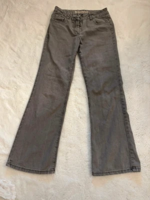 Grå bootcut jeans med broderade fickor - Säljer ett par gråa bootcut jeans med snygga broderade detaljer på bakfickorna. 