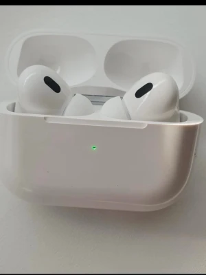 AirPods Pro - Apple AirPods Pro trådlösa hörlurar med aktiv brusreducering och laddningsetui. Komplett med originalförpackning, laddkabel och dokumentation. Hörlurarna och etuiet ser ut att vara i mycket gott skick utan synligt slitage.