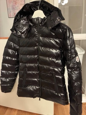 Moncler Bady jacka - Moncler bady jacka till tjejer.   Perfekt vår/höstjacka, funkar också till vinter  Storlek: 2 motsvarande till M men den är mindre i storlek så sitter bättre på en S.   Skick: Helt ny då den inte kommit till användning   QR kod och NFC Scan finns och bekräftar äkthet. Dustbag medföljes. 