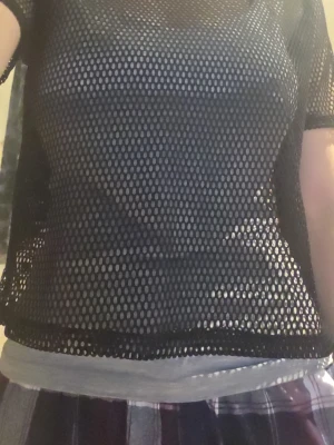 Svart nät topp med kort ärm - Säljer en svart mesh topp med korta ärmar. Toppen är helt genomskinlig med stora hål och har en loose passform. Perfekt att bära över ett linne eller bralette för en edgy look.