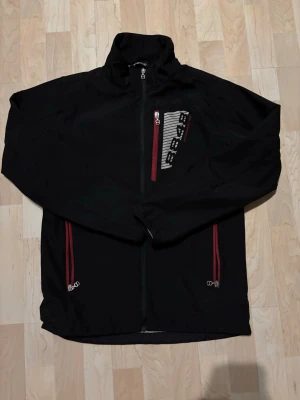 Svart vindjacka 8848 Altitude  - Svart vindjacka från 8848 Riktig schysst jacka som väldigt enkelt kan stylas i samband med annat för en snygg outfit. Höga kragen på jackan gör den riktigt unik. Jackan är i princip oanvänd och har inga defekter!