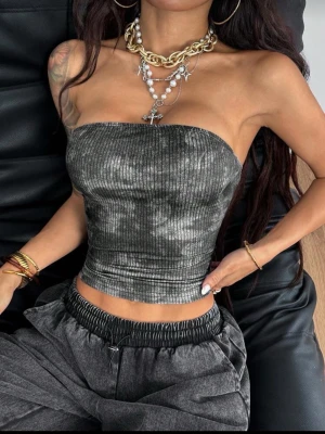 Mörkgrå ribbad tubtopp - Säljer en mörkgrå ribbad tubtopp med lätt marmorerad effekt. Toppen är croppad och sitter tight runt kroppen. Perfekt för dig som gillar minimalistisk och edgy stil. Materialet känns mjukt och stretchigt, vilket gör den bekväm att bära hela dagen.