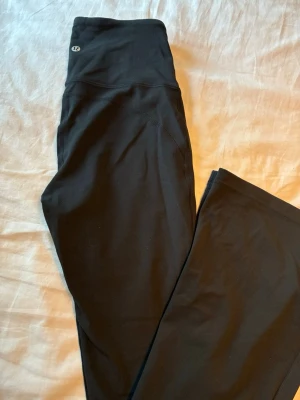 Svarta Lululemon Groove tights - Supersnygga svarta tights från Lululemon, modell Groove Super-High-Rise Flared Nulu. De har hög midja och utsvängda ben, tillverkade i mjukt och stretchigt syntetmaterial som sitter skönt mot kroppen. Perfekta för träning eller chill. Använt endast två ggr. 