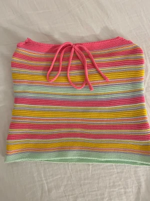 Tub topp med knyt rosett framtill - Somrig tub topp. Köpt på Vinted men har endast använt en gång, väldigt fint skick och inga synliga tecken på användning. Vet tyvärr inte storlek eller vilket märke den e ifrån då det inte sitter kvar någon lapp på tröjan 