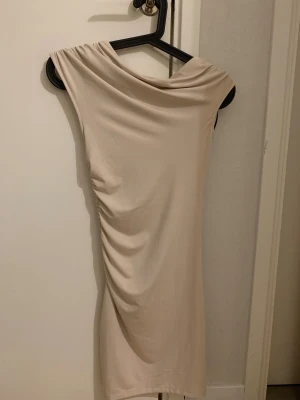 Beige klänning hm - En beige klänning från hm i storlek Xs. Har veckat tyg på ena sidan i midjan och på axeln. Jätte snygg klänning men har inte kommit till särskilt mycket användning för mig.💕 pris gå alltid att diskuteras