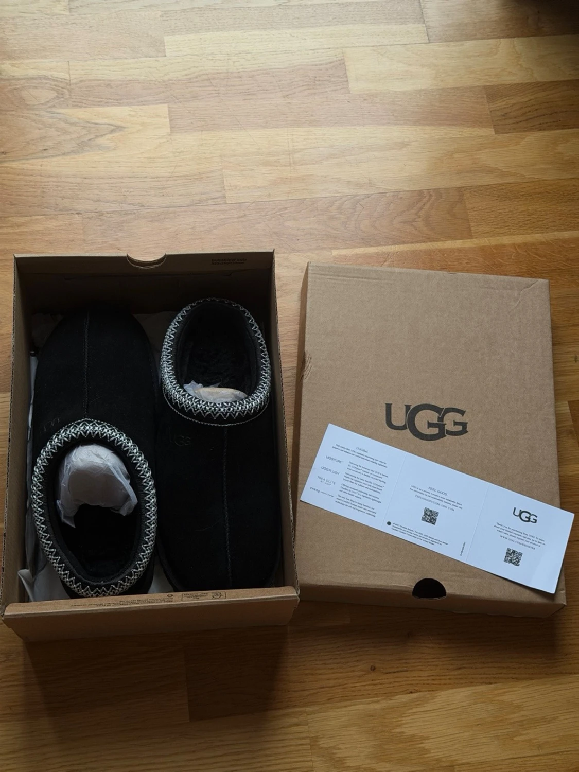 Svarta UGG slip-on skor med mönstrad kant