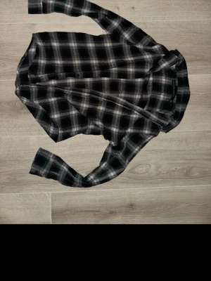 Svartvit rutig skjorta Black Label - Säljer en svartvit rutig skjorta från The Black Label Collection i storlek S. Skjortan har klassisk krage, knappar framtill och långa ärmar. Perfekt för dig som gillar en chill och stilren look. Materialet känns mjukt och bekvämt mot huden.