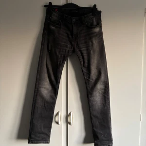 Svarta Jeans med slitningar - Tja, säljer nu mina svarta tvättade jeans märkta SMOG/DENIM. De har en Slim/Straigh Passform med slitningar på både bakfickor och benen. De är i storlek W29 L30, använda några gånger och inga defekter. Tveka inte på att höra av er vid frågan efter bilder på hur de sitter på eller vid andra frågor!💯
