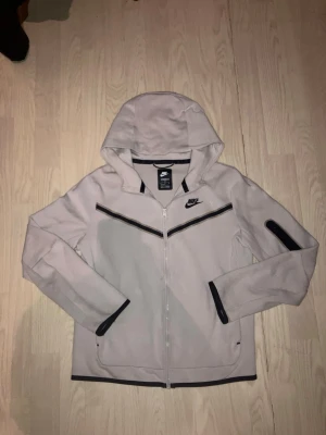 Vit Nike tech - En fin vit Nike tech i "mycket bra skick” använd  i gott skick, i skönt material och funkar till daglig användning, med lite snyggare kick. Pris går att diskutera vid snabb affär! 160-170cm