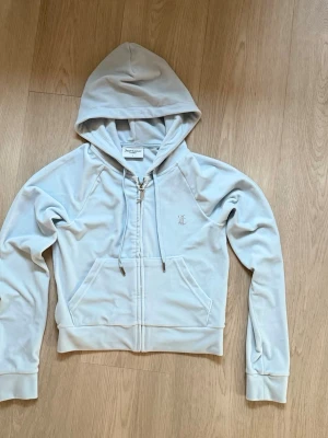 Juicy couture zip hoodie - Juicy couture zip hoodie i ljusblå färg. Tröjan är i nyskick och använd runt en gång med noll defekter. Den är i storlek S. Säljer pga att den aldrig kommit till användning.💓