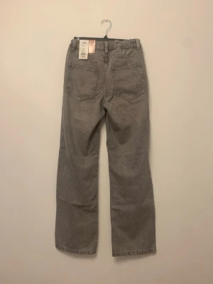 Grå loose fit jeans från SAM - Säljer ett par ljusgrå jeans från SAM i loose fit med regular waist. Klassisk femficksmodell och raka ben. Perfekta för dig som gillar avslappnad stil och vill ha bekväma jeans i vardagen. Storlek 164.