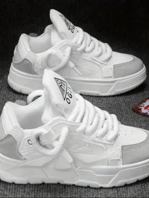 Vita chunky sneakers med grå detaljer - Säljer ett par vita chunky sneakers med grå detaljer och tjock sula. Skorna har snörning och en rund tå, samt en logga på plösen. Materialet är syntet och textil, vilket gör dem både lätta och bekväma. Perfekta för dig som gillar streetstyle.