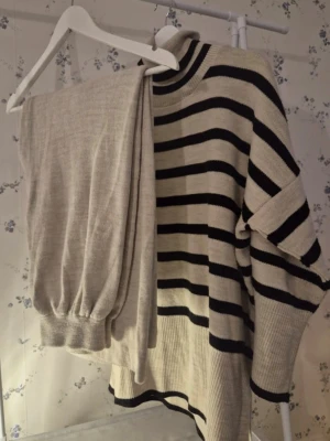 Beige och svart randig  stickat set - Säljer en beige och svart randig stickat set ifrån SHEIN  i storlek S. Tröjan har breda svarta ränder, hög polokrage och är långärmad, och byxorna är i fint skick . Materialet är mjuk akryl som känns skönt mot huden. Perfekt för dig som gillar en chill och stilren look.