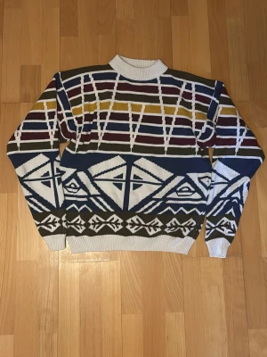 Färgglad stickad tröja med grafiskt mönster - Tröjan har rund hals med ribbad kant och långa ärmar, lite schysstare inför vintern och varm. Vid fler frågor hör av er.