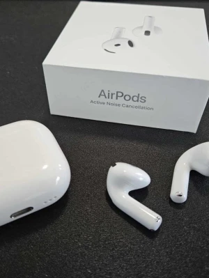 Apple AirPods (Active Noise Cancellation) - Snygga trådlösa Apple AirPods med aktiv brusreducering. Levereras med originalförpackning och laddningsetui. Hörlurarna är i gott skick men har mindre repor och slitage, vilket syns på bilderna. Perfekt för musik, samtal och träning.