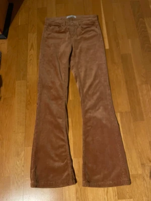 Bootcut manchesterbyxor från Zara Woman - Snygga bootcut manchesterbyxor från Zara Woman Premium Denim Collection i en varm brun färg. Byxorna har klassisk femficksdesign, knapp och dragkedja fram samt mjukt manchestertyg som ger en skön retrovibe. Perfekt för dig som gillar lite bredare ben och cool stil. Storlek 34 eller xs.