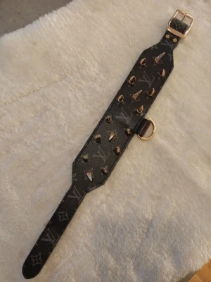 Emiliush svart/guld nitad hundhalsband+koppel  - Unik custom made svart/guld med L√ monogram och guldiga nitar. Halsbandet har bred form, justerbart spänne och D-ring i metall. Materialet är skinn med tryckt logga och detaljer i guld. Perfekt för dig som gillar edgy och lyxig stil. Str på halsbandet är 40-51 och kopplet är ca 90cm långt