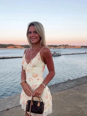 Blommig volangklänning från Stradivarius - Superfin kort klänning från Stradivarius i ljusa toner med blommigt mönster i persika och beige. Klänningen har smala axelband, v-ringning med volangdetaljer och en flowy kjol. Gratis frakt idag!🙌🏼🤩 nypris 379kr. Kan posta till och med torsdag (1 jan) sedan är jag bortrest i Januari och Februari✨✨