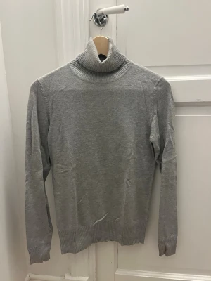 Grå polotröja från Saint Tropez XS - Säljer en stilren grå polotröja från Saint Tropez i storlek XS. Tröjan har ribbad polokrage, muddar vid ärmslut och nederkant samt lång arm..