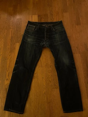 Nudie Steady Eddie Dry Selvedge Jeans - Nudie Steady Eddie Dry Selvedge jeans Nudie steady eddie dry selvedge w33 L34 / väldigt bra skick Mått: Ytterbenslängd: 104 Midja:42