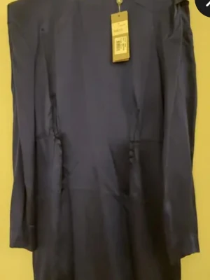 Blå klänning Tiger of Sweden - Snygg blå klänning från Tiger of Sweden i siden. Klänningen har lång ärm och en stilren design med dragkedja bak.Perfekt för dig som gillar klassiska och eleganta plagg med exklusiv känsla. Storlek 40.