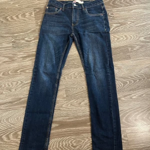 Levi's 512 Slim Taper jeans mörkblå - Snygga Levi's 512 Slim Taper jeans i mörkblå tvätt med klassiska fem fickor och gul kontrastsöm. Jeansen har en smal passform med avsmalnande ben och är tillverkade i bomull. Perfekta för dig som gillar en clean och modern look. Pris går ej att diskutera