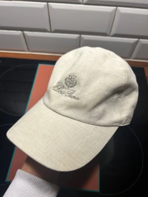 Loro Piana keps  - Lycka till att hitta bättre pris. Säljer nu min sjukt snygga Loro Piana keps i linne material, köpt innan sommaren detta år för 4600kr, kvitto finns. Inte använt så många gånger, dock en liten fläck som mestadels är synlig nu vid bilder i starkt ljus men ej vid användning. Perfekt för alla outfits! Hör av er vid frågor & funderingar🤝