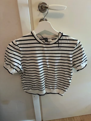 Randig vit och svart topp från HM - Säljer en fräsch vit randig topp från HM. 