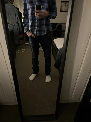 Mörkblå skinny jeans från Nudie Jeans - Säljer ett par mörkblå jeans från Nudie Jeans i storlek 28/32. Jeansen har klassisk femficksdesign, kontrastsömmar och Nudie-logga på bakfickan. Materialet är slitstarkt denim med snygga tvättade detaljer och smal passform. Priset kan diskuteras.