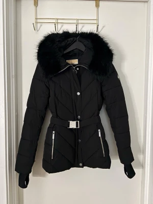 Svart Michael Kors jacka - Säljer min svarta Michael kors vinter jacka som jag knappt använt överhuvudtaget. Storlek xs. Jätte fin passform man kan ta av både pälsen och bältet om man vill. Pris går att diskutera💗orginalpris 3500kr 