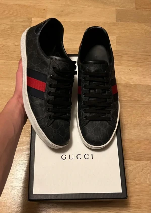 Gucci Ace sneakers - Gucci ace i grå/svart färg perfekta inför vintern eftersom de är i en mörk färg. Ser nya ut förutom lite slitningar på insidan vilket egentligen inte spelar roll eftersom det inte syns. Passar mig som har strl 42