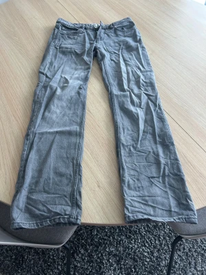 Grå jeans  - Snygga grå jeans från Lager 157 i modellen Icon med klassisk femficksdesign och raka ben. Jeansen har knappgylf med fyra knappar. Det finns två röda små fläckar på byxorna från målarfärg som knappt syns💕 Storlek S