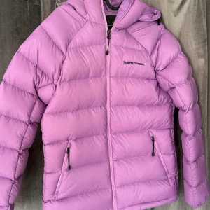 Lila Peak Performance pufferjacka - Säljer en lila pufferjacka från Peak Performance. Använd max 2 gånger. Köptes förra året i butik. Passar mig bra som brukar ha S.  pris går att diskutera!!