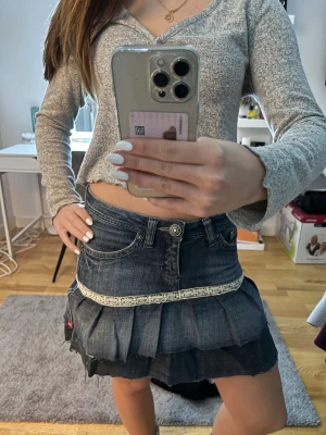 Mörkblå jeanskjol med spets från Esprit - Supersöt mörkblå jeanskjol från Esprit med volanger och råa kanter. Kjolen har en vit spetsdetalj runt om och klassiska jeansfickor både fram och bak. Perfekt för dig som gillar en edgy och feminin stil.