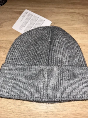 Grå ribbad Moncler mössa - Oanvändt, ville ha en svart men jag fick en grå iställer så jag blev missnöjd.
