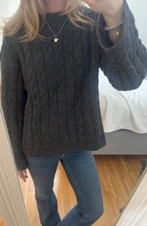 Mörkgrå stickad tröja från H&M - Mysig mörkgrå stickad tröja från H&M i storlek XS. Tröjan har ett klassiskt kabelstickat mönster, rund hals och långa ärmar. Såå skön, speciellt till vinter! ❤️⭐️☃️pris kan diskuteras!! 💕