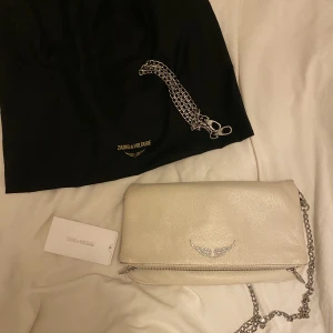 Vit Zadig väska  - Säljer min vita Zadig & Voltaire väska! Den är i använt skick och jag har även dragit ut den svarta läder-rämmen på båda kedjorna (oopps🫣), tyckte det såg bättre ut..  Pris kan diskuteras och om du vill ha fler bilder så är de bara att skriva till mig🩷