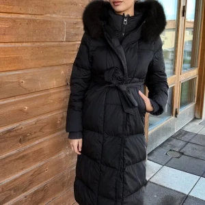 Feminina Svart lång dunjacka med päls - Jätte fin vinterjacka i storlek S, endast använd en vinter men kommer tyvärr inte till användning längre. Inga skador eller fläckar eller något liknande på jackan och den är i jätte fint skick. Köpt för lite mer än 3000kr och säljs nu för 2300kr