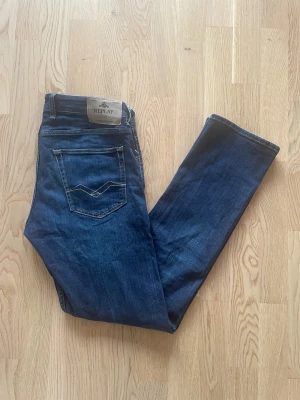 Mörkblå Replay Grover jeans W33 L34 - Jag säljer dom här riktigt snygga Replay Grover jeansen som är i storlek W33 L34. De är knappt använda och är i fint skick utan skador. Tveka inte att höra av er!                                                        Mått: Längd=109cm. Midja=46cm