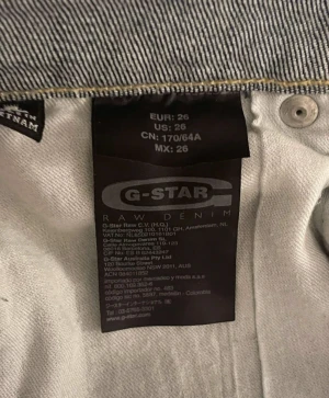 G-Star dam blå denimkjol i casual-modell - Snygg blå jeanskjol från G-Star RAW med klassisk femficksdesign, knapp och dragkedja framtill samt detaljer på bakfickorna. Kjolen har en kort och rak passform med slitningar. 