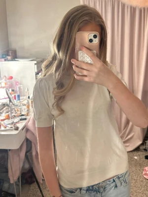 Vit basic t-shirt i bomull - Enkel och stilren vit t-shirt i mjuk bomull. Klassisk passform med rund hals och korta ärmar, perfekt till jeans eller shorts. Inga synliga tryck eller detaljer, bara en clean och tidlös look.