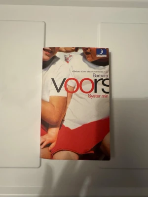 Syster min av Barbara Voors - En roman av Barbara Voors med titeln 'Syster min'. Omslaget visar två personer i vita tröjor och röda kjolar. Boken handlar om tvillingsystrar, försvinnande och familjehemligheter. Pocketutgåva från Månpocket.