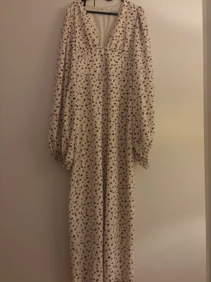 Adooreklänning - Säljer min fina adooreklänning då det blivit för stor för mig. Det är i motivet med röda körsbär. Endast använd en gång så den är i nyskick. Vid snabb affär kan priset diskuteras.