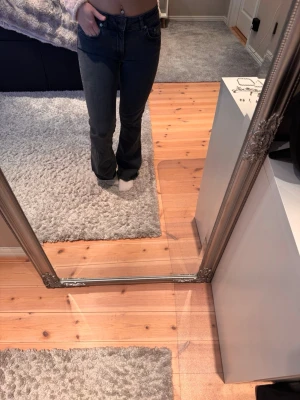 Svarta bootcut jeans med hög midja - Snygga svarta bootcut jeans med hög midja och klassiska fem fickor. Jeansen har en tight passform upptill och släpper ut lite vid benen för en trendig siluett. Perfekta till crop tops eller hoodies för en chill look.