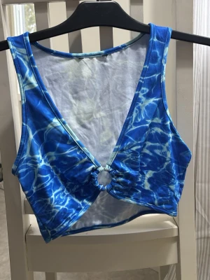Blå mönstrad croppad topp - Blå topp med vatten liknande mönster, aldrig använd