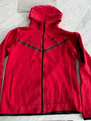Nike tech - snygg röd nike kofta väldigt använd så lite sliten säljs därför billigt, inga hål eller liknande storlek S!
