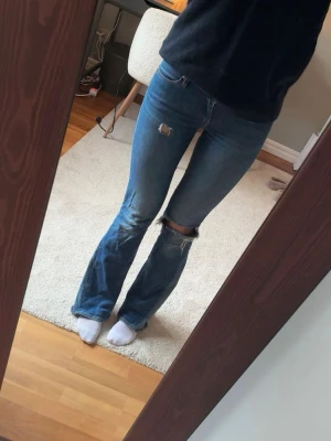 Lågmidjade utsvängda acne jeans  - Lågmidjade bootcut jeans från acne, med hål i och insydda revärer 